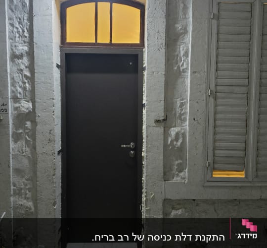 דלת שחורה עם חלון עליון מואר